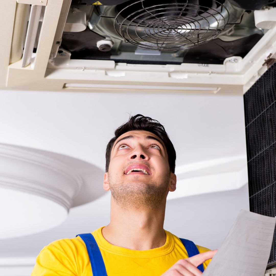 Man looking at a vent and checking a warranty