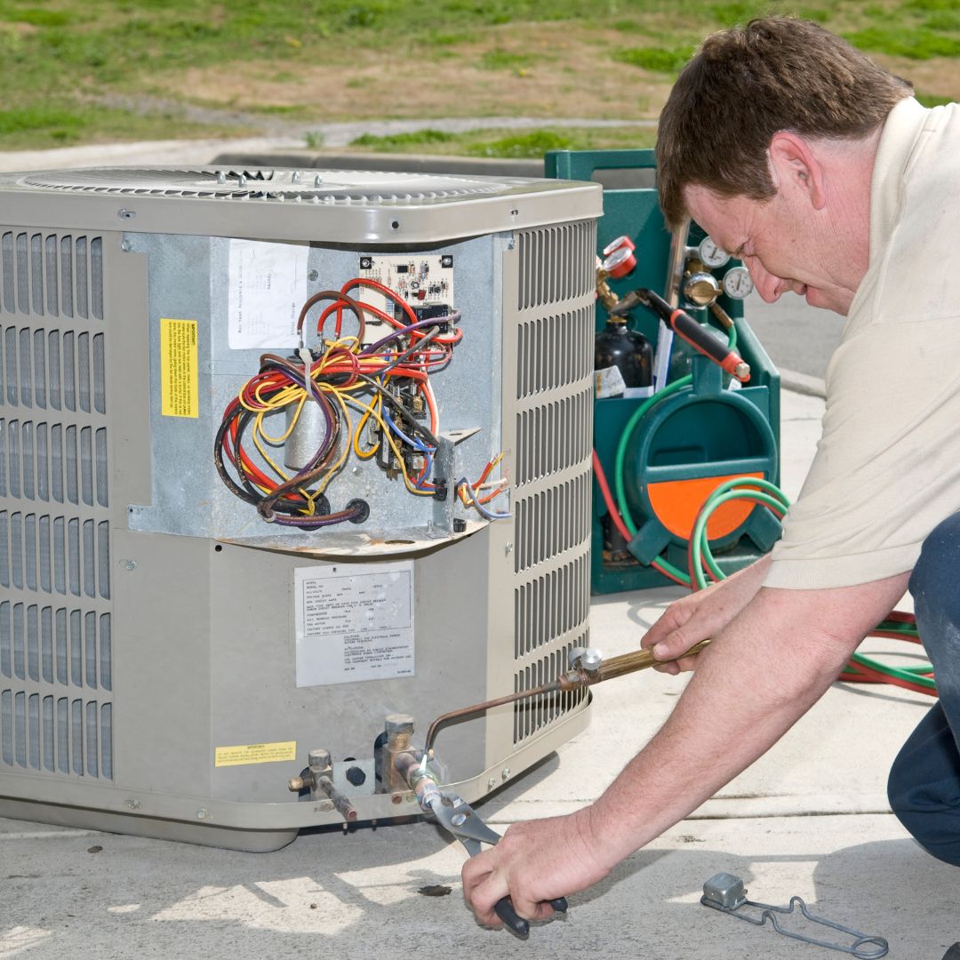 man repairing an AC unit