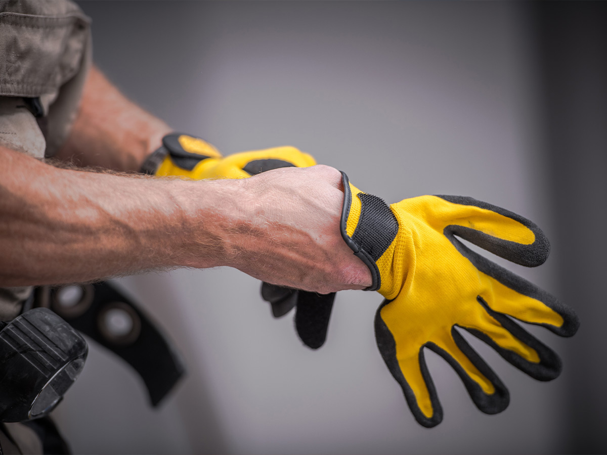Image of a plumber putting on gloves.