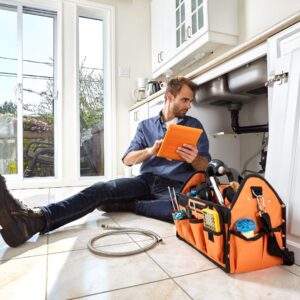 plumber taking notes on faucet pipes