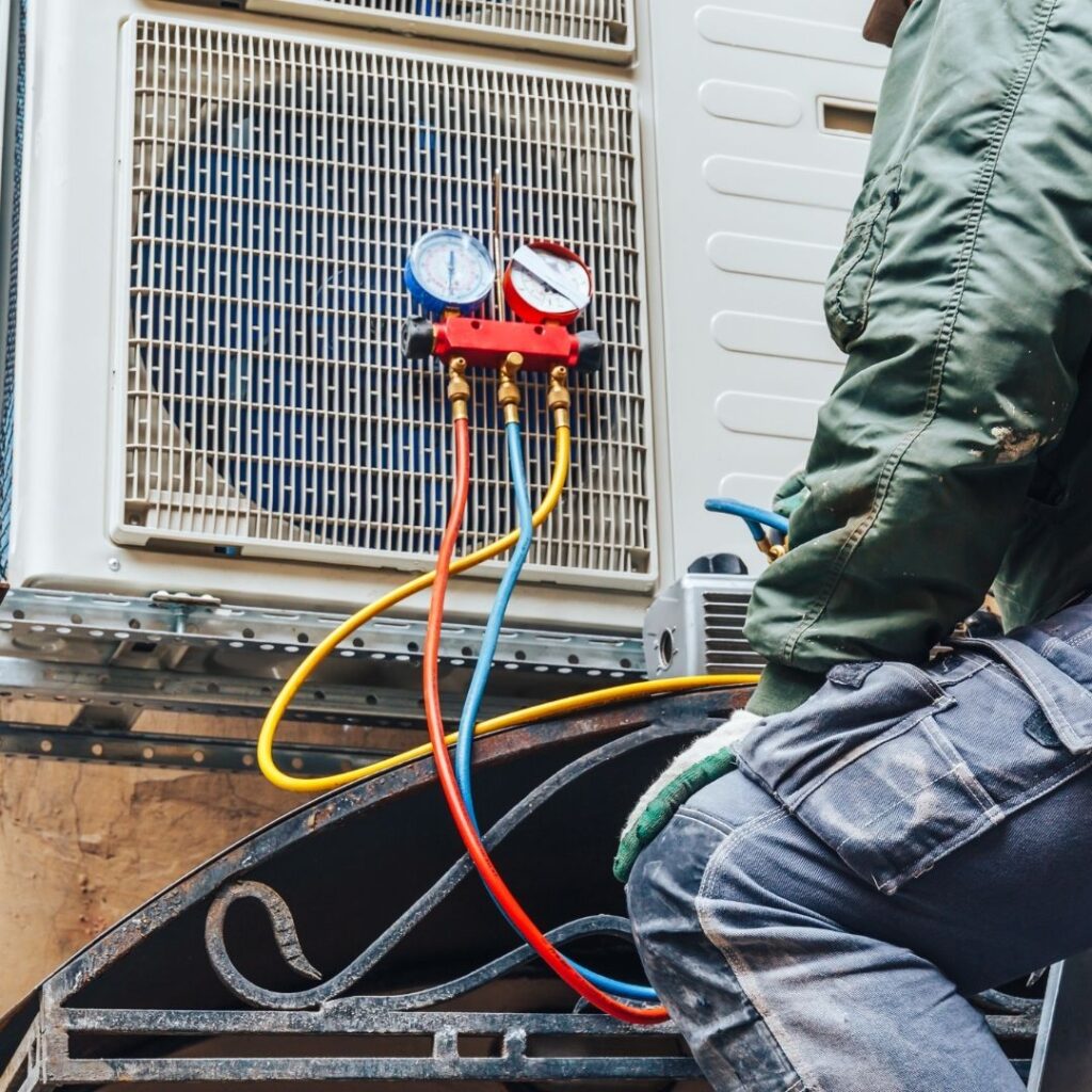 man hooking cords into an outdoor AC fan