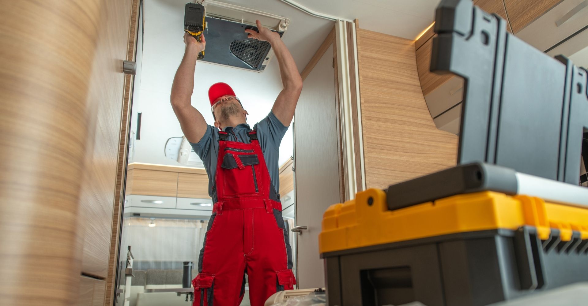 man in red overalls working on AC
