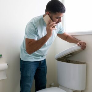 man on phone lifting toilet cover
