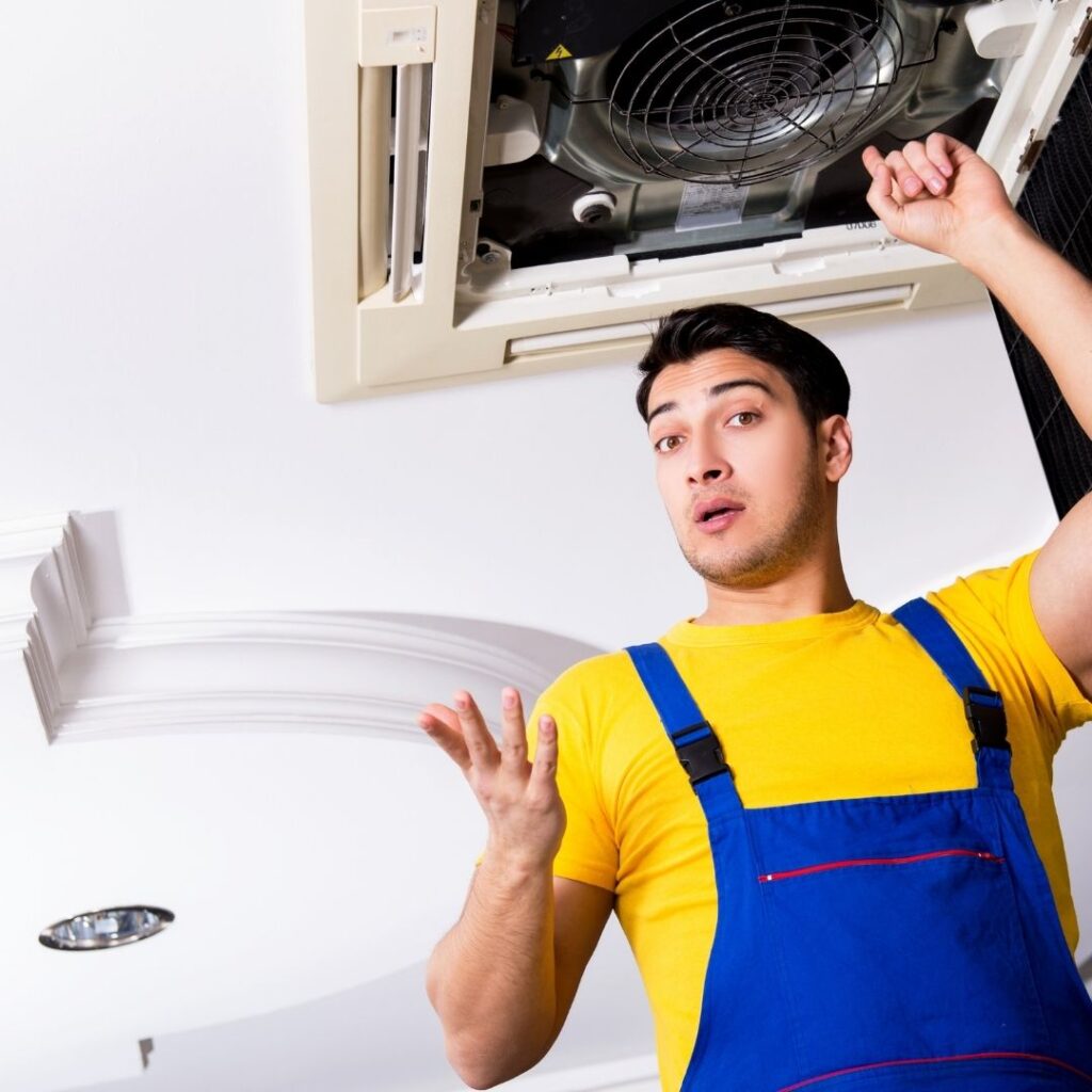 man looking confused as he works on AC