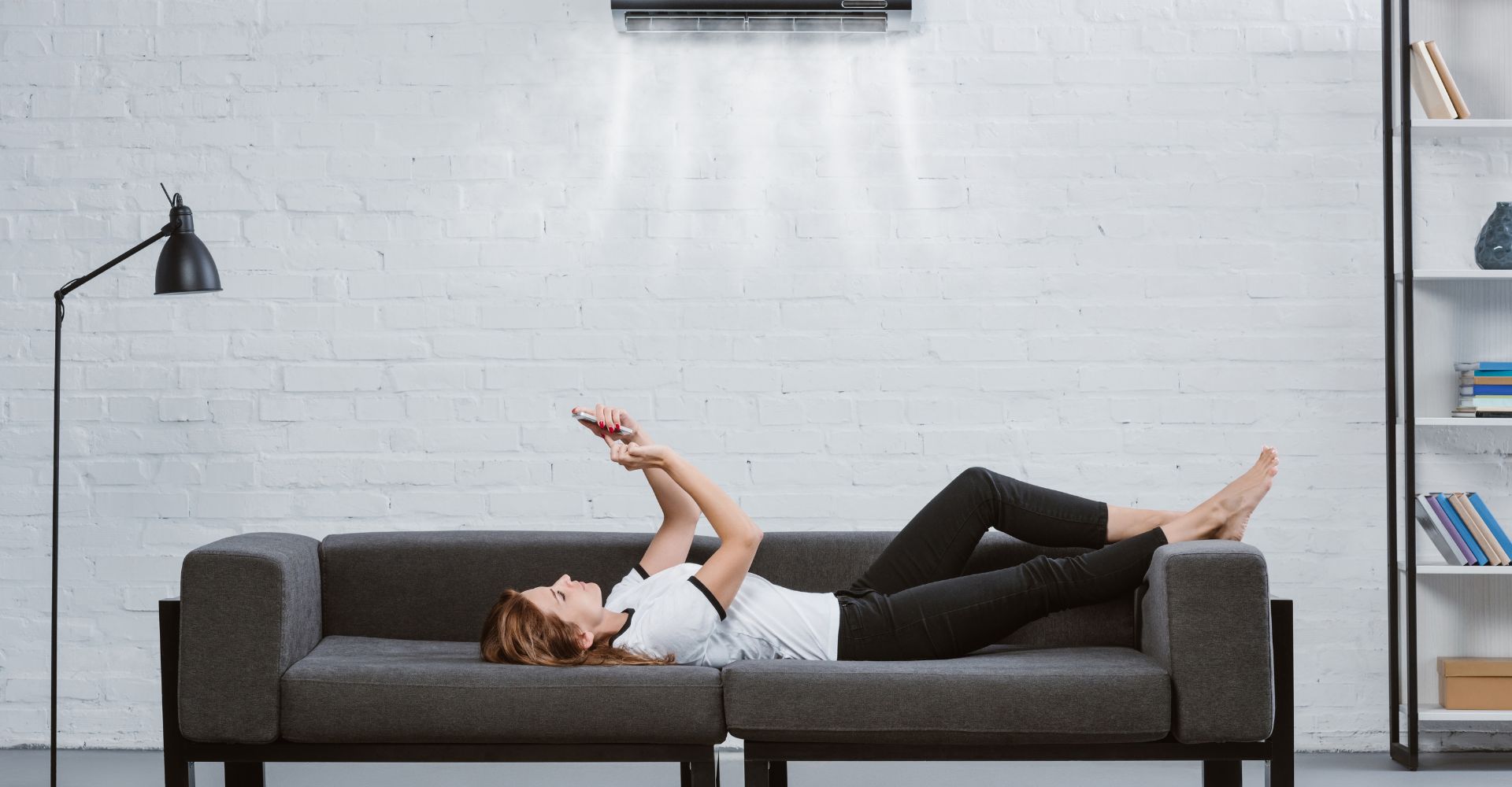 A woman laying on the couch enjoying the AC.