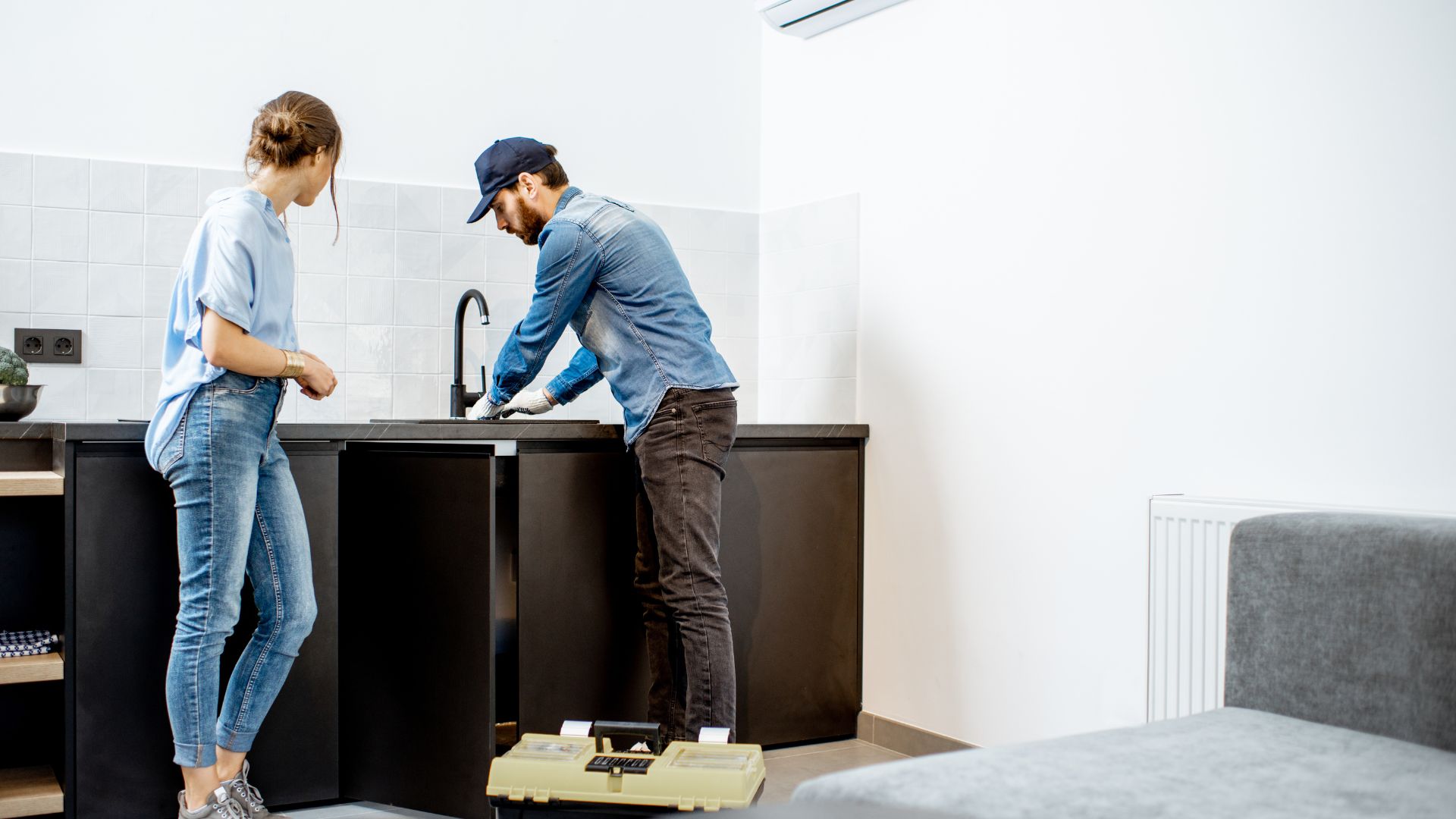 Customer watching plumber work on sink
