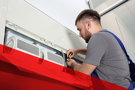 a professional working on a wall ac unit