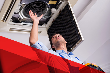 a professional working on a ceiling ac unit
