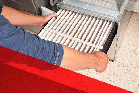 person removing filter from furnace