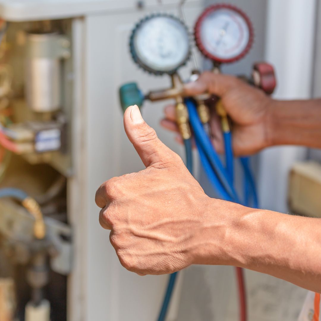 a thumbs up in front of an air conditioner unit