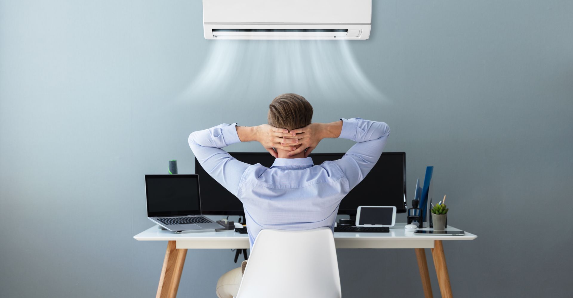 man by his computer with an AC overhead