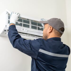 a repairman fixing an ac unit