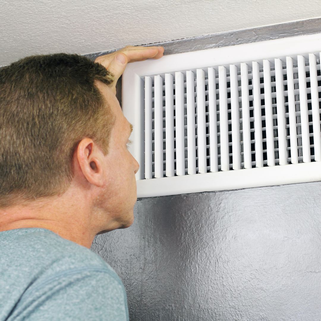 a man feeling the airflow of a vent