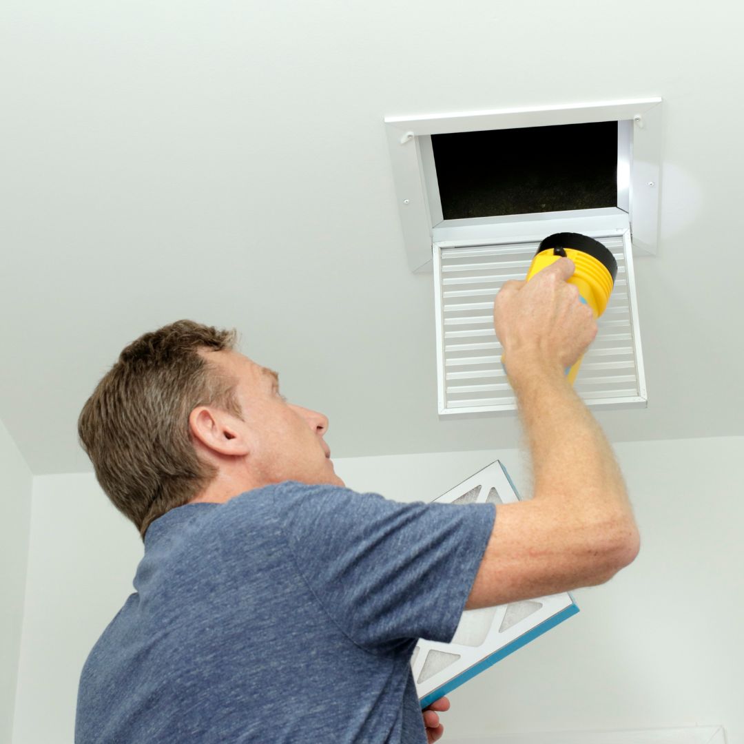 a man inspecting a vent