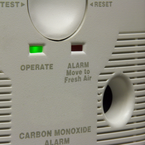 A person reacting to a strong gas smell in a kitchen